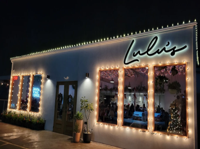 Lulu's at Stinson Yard glowing with string lights at night